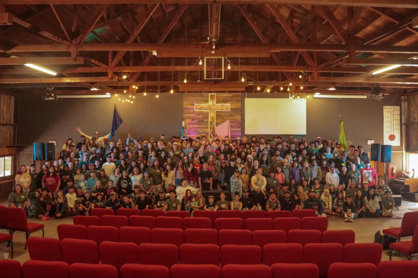 A large crowd of students gathered in an auditorium at a youth event